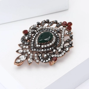 Vintage bronze brooch featuring deep green teardrop gemstone and sparkling rhinestones