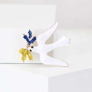 Spilla colomba in smalto bianco elegante con foglie di cristallo blu e gialle su sfondo bianco