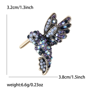 Detailed macro view showing dimensions of a hummingbird brooch with colorful rhinestones