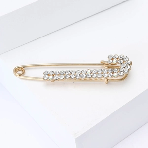 Detailed close-up of golden brooch pin with double rows of sparkling rhinestones