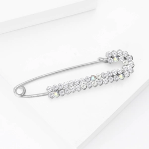 Macro detail of silver alloy safety pin brooch with double-row sparkling rhinestones