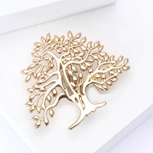 Macro shot of a polished gold alloy tree of life brooch on a white geometric stand