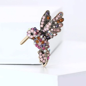 Detailed shot of hummingbird brooch with colorful rhinestones on white platform
