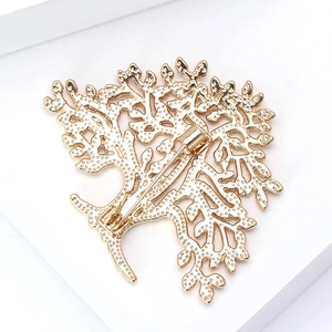 Macro detail of the revolving pin buckle on the golden tree-shaped brooch back structure