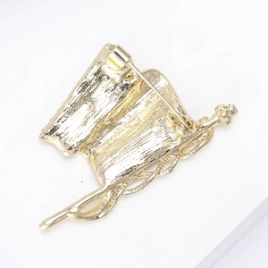Detail of the golden alloy brooch back featuring a secure pin and hammered metal texture