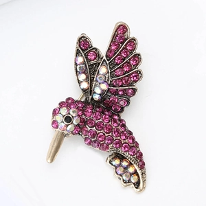 Close-up of hummingbird brooch with rose red crystals and iridescent rhinestone details