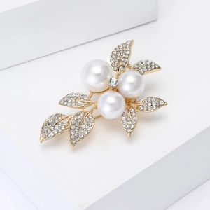 Detailed view of alloy leaf brooch featuring white pearls and sparkling rhinestones