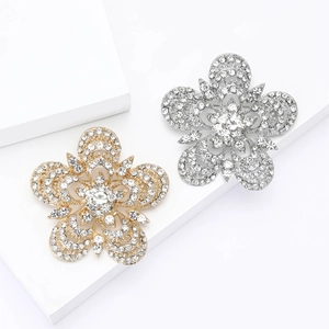 Broches fleurs en strass étincelants en or et argent sur un support géométrique