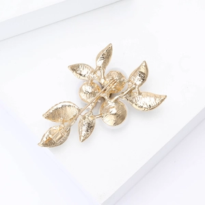 Detailed back view of a gold leaf brooch with a functional pin clasp and polished finish