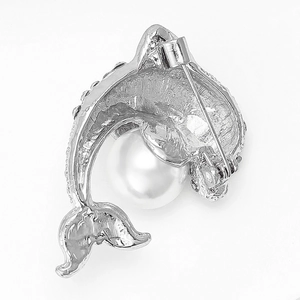 Détail du dos de la broche dauphin argentée montrant le fermoir à épingle et la perle ronde