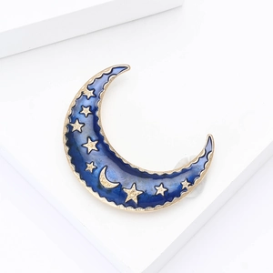 Détail d'une broche croissant de lune avec émail bleu et ornements d'étoiles dorées