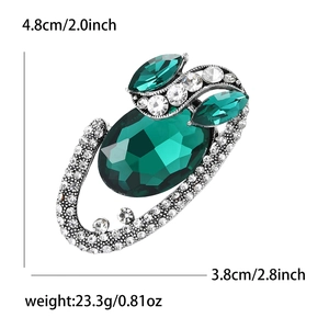 Vintage oval emerald green crystal brooch with silver alloy frame and white rhinestones