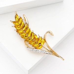Broche élégante en forme d'épi de blé doré avec strass brillants sur socle blanc