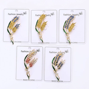 Detailed close-up of wheat ear brooches with colorful rhinestones on display cards