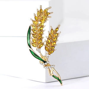 Golden wheat brooch with yellow crystals, green enamel leaves, and white zircon accents