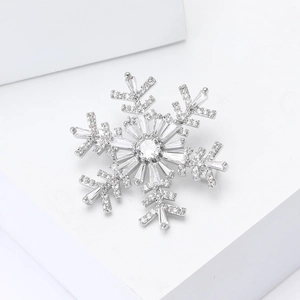 Detailed close-up of a silver snowflake brooch with sparkling cubic zirconia on white stand