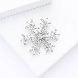 Macro shot of luxury silver snowflake brooch with sparkling cubic zirconia on white block