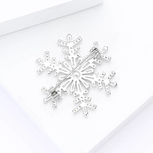 Detailed back view of silver snowflake brooch with secure pin clasp and rhinestones