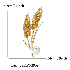 Elegant gold wheat brooch with amber rhinestones and white pearl on white background
