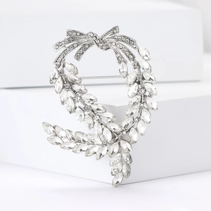 Elegant silver wheat ear brooch with sparkling marquise crystals on a white pedestal