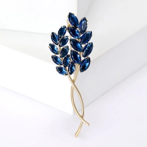 Élégante broche épi de blé dorée avec pierres marquises bleu marine sur fond blanc