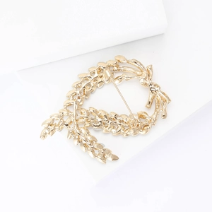 Detailed back view of a gold wheat stalk brooch showing pin fastening and polished finish
