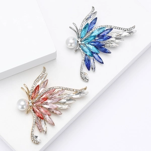 Élégantes broches papillon en cristal avec strass et perles sur socle blanc