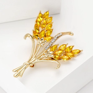 Macro shot of golden wheat ear brooch with yellow marquise crystals and clear rhinestones