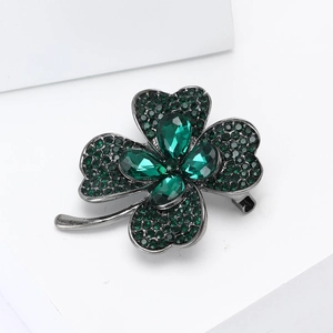 Détail de la broche trèfle à quatre feuilles avec cristaux vert foncé sur base en alliage