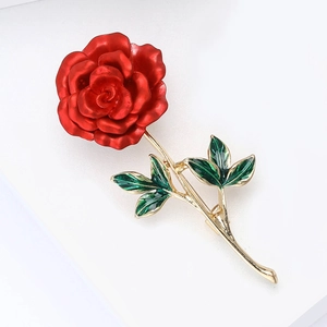 Elegant red enamel rose brooch with gold leaves on a white minimalist background