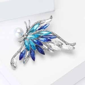 Détail macro d'une broche papillon en cristal avec perle et pierres marquises bleues