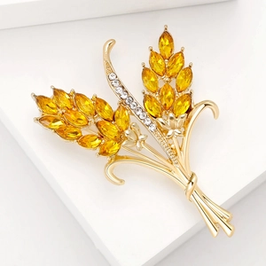 Macro detail of golden wheat ear brooch with yellow crystals and white zircons