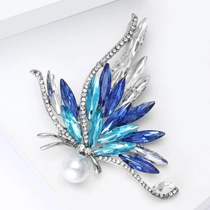 Gros plan sur la luxueuse broche papillon en cristal bleu avec perle blanche fine