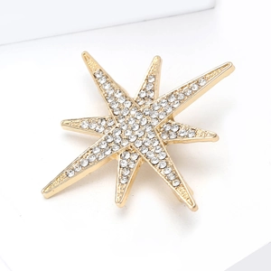 Detailed macro view of an eight-pointed star brooch with inlaid white diamonds and gold plating