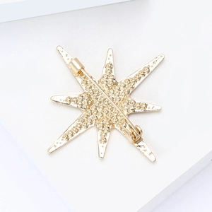 Detailed back view of golden starburst brooch with secure safety pin clasp closure
