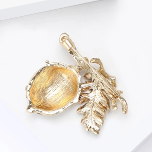 Elegant gold alloy chestnut brooch with rhinestones and leaf design seen from the back