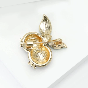 Back view of gold alloy enamel pomegranate brooch with secure rotating safety pin clasp