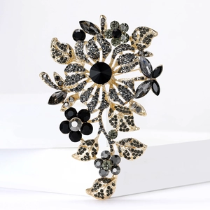 Detailed macro of crystal flower brooch with black rhinestones on gold alloy base