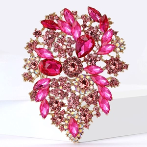 Detailed close-up of a floral heart-shaped brooch with pink and rose crystals in gold alloy