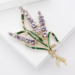 Détail de la broche lavande avec strass mauves et feuilles vertes sur base dorée