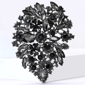 Detailed macro view of vintage alloy brooch with dark rhinestones on white platform