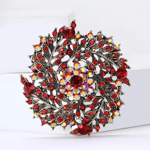 Vue détaillée d'une broche couronne de blé vintage avec strass rouges et fini doré