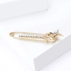 Gros plan sur la broche épingle dorée avec étoile scintillante et strass incrustés
