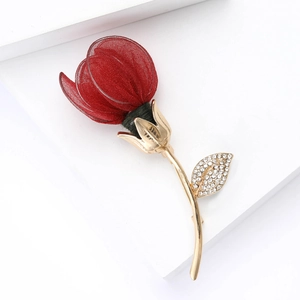 Detailed close-up of a deep red mesh fabric flower brooch with gold leaves and crystals