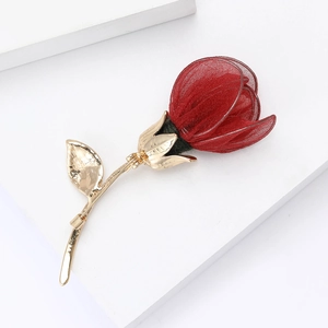 Macro shot of red mesh rose petals and gold metal leaf stem on elegant brooch pin