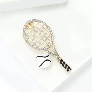 Detail shot of tennis racket brooch featuring white crystals and enamel on gold alloy