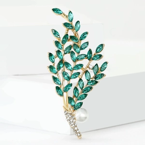 Elegant gold willow branch brooch with green crystals and a large white pearl accent