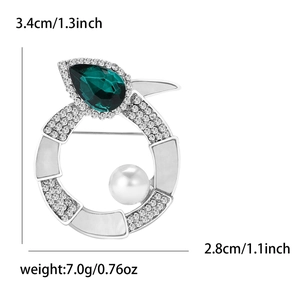 Detailansicht der silbernen Brosche mit birnenförmigem grünem Stein, Perle und Strasssteinen