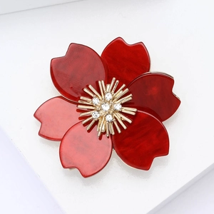 Detail of red marble texture petals and golden rhinestone center of flower brooch