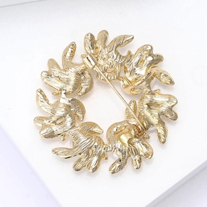 Macro shot of gold brooch back showing secure safety pin and textured metal finish